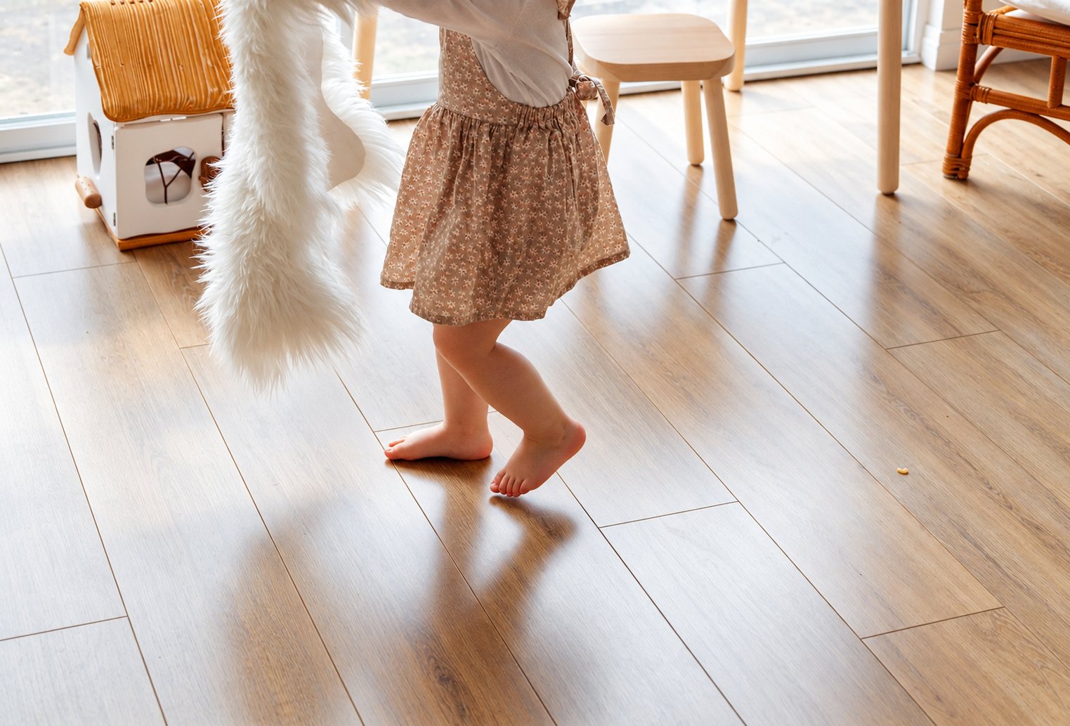Barefoot child dancing on a warm, sunlit floor
